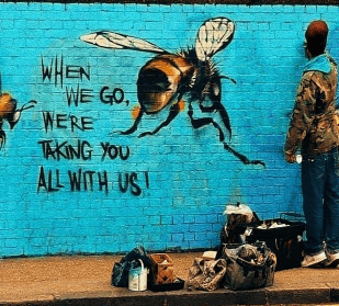 Street Art with bees and the words When we go, we're taking you all with us